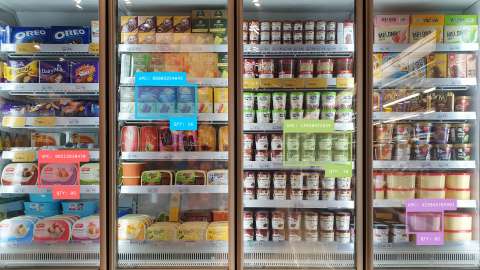 有四個玻璃門的超市冷藏系統，可展示各種產品。產品與冷藏箱部分區域上有多個 AI 推論矩形與標籤，表示正在使用電腦視覺系統完成自動庫存管理